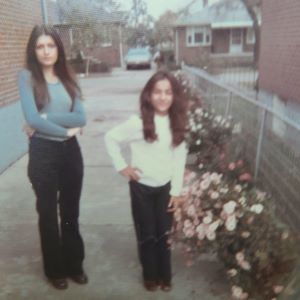 Veronica and Virginia as children standing in a driveway in the spring.